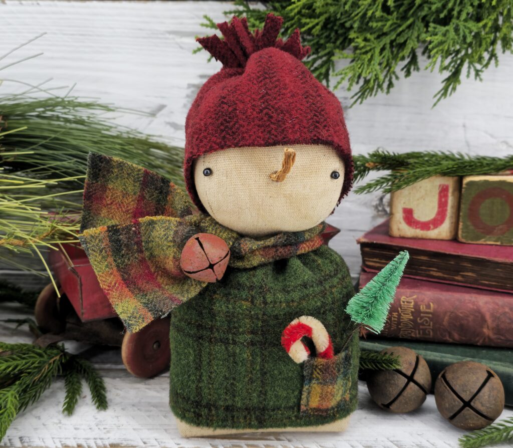 Handmade winter wool snowman shelf sitter, rustic farmhouse Christmas décor with red hat, green sweater, scarf, carrot nose, and snowflake accent