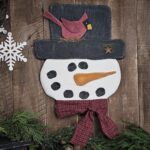 Handmade primitive snowman door hanger, rustic farmhouse winter holiday décor with plaid scarf, muslin hat, and rusty star accent