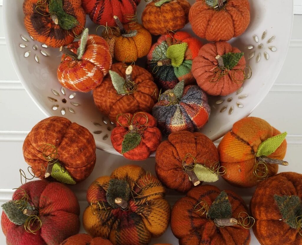 Bowl filled with mini flannel woolies pumpkins in assorted fall fabrics with real wood stems and wool leaves