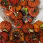 Bowl filled with mini flannel woolies pumpkins in assorted fall fabrics with real wood stems and wool leaves