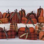 Large grouping of primitive homespun fabric pumpkins with real wood stems, green ties, and wire tendrils