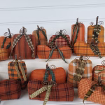 Close‑up of primitive homespun pumpkin with boxed weighted bottom, real stem, and fall homespun fabric