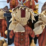 Close‑up of handmade scarecrow face with osnaburg fabric, stitched details, and aged primitive finish