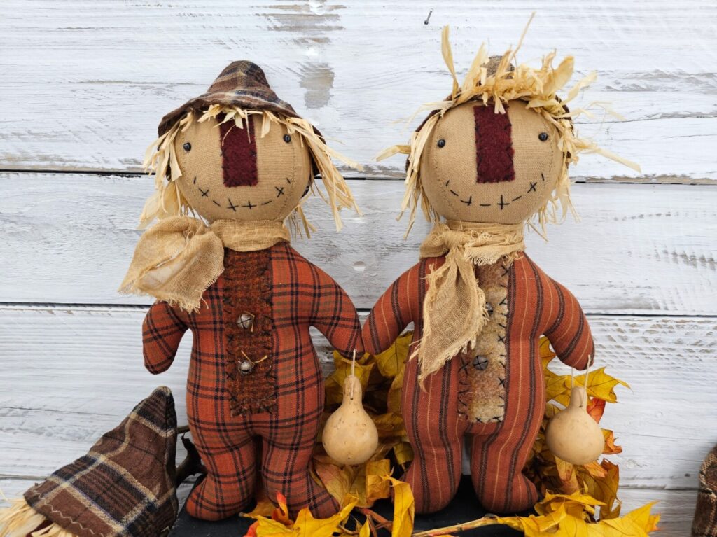 Side‑by‑side close‑up of primitive fall plaid and fall ticking homespun fabrics used for scarecrow body options