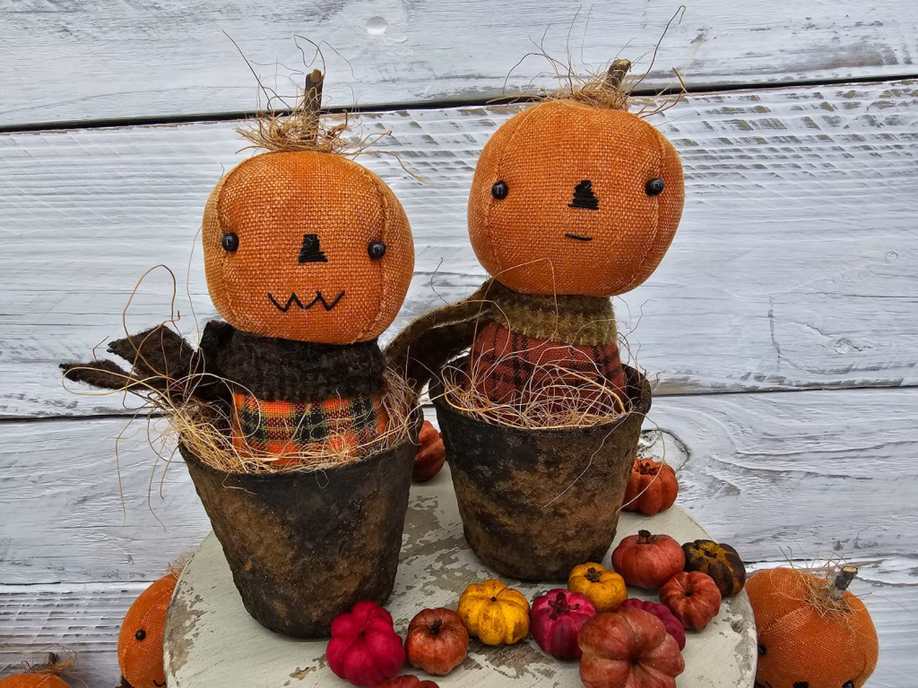 Primitive pumpkin shelf sitters in faux rusty pots showing both stitched mouth options: straight‑line and zig‑zag