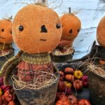 Group of a few primitive pumpkin shelf sitters in faux rusty pots with stitched faces, real stems, and homespun fall fabrics