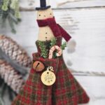 Primitive wool mitten snowman door greeter used as a rustic farmhouse wall accent for winter decorating.