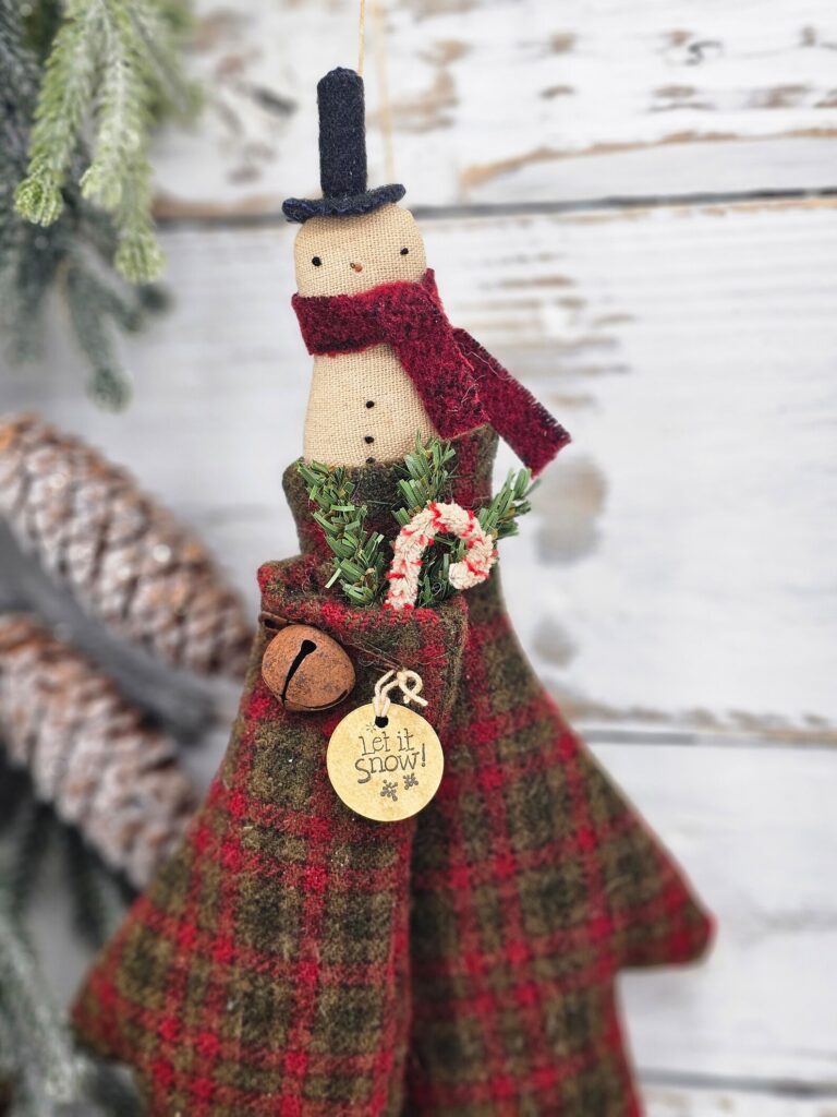 Primitive wool mitten snowman door greeter used as a rustic farmhouse wall accent for winter decorating.