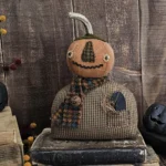 Handmade fall pumpkin shelf sitter with real stem, stitched face, and homespun body