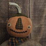 Rustic Halloween pumpkin man décor with wool nose, rick‑rack mouth, and removable crow