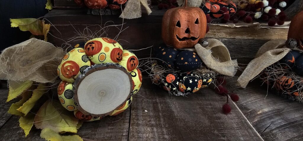 Bottom view of primitive Jack‑O‑Lantern stack showing real wood slice base with natural bark edge and smooth finish