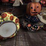 Bottom view of primitive Jack‑O‑Lantern stack showing real wood slice base with natural bark edge and smooth finish