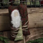 Back view of primitive wool Santa tuck showing needle‑felted wool hair, aged osnaburg body, and red wool sack.