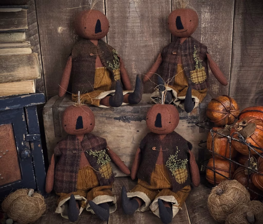 Handmade primitive pumpkin boy doll with stitched wool face, vintage vest, and fall décor accents