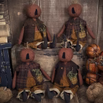 Handmade primitive pumpkin boy doll with stitched wool face, vintage vest, and fall décor accents
