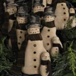 Primitive snowman tuck body with hand‑stitched details, wool scarves, and rustic painted accents.