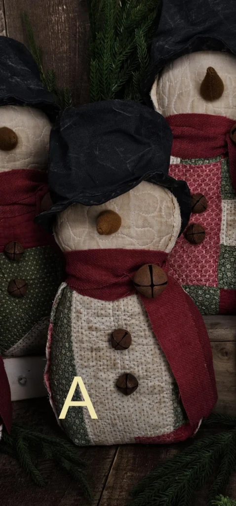 Primitive quilted snowman, Variant A, made from vintage patchwork quilt with red‑green‑cream blocks; letter A shown on photo.