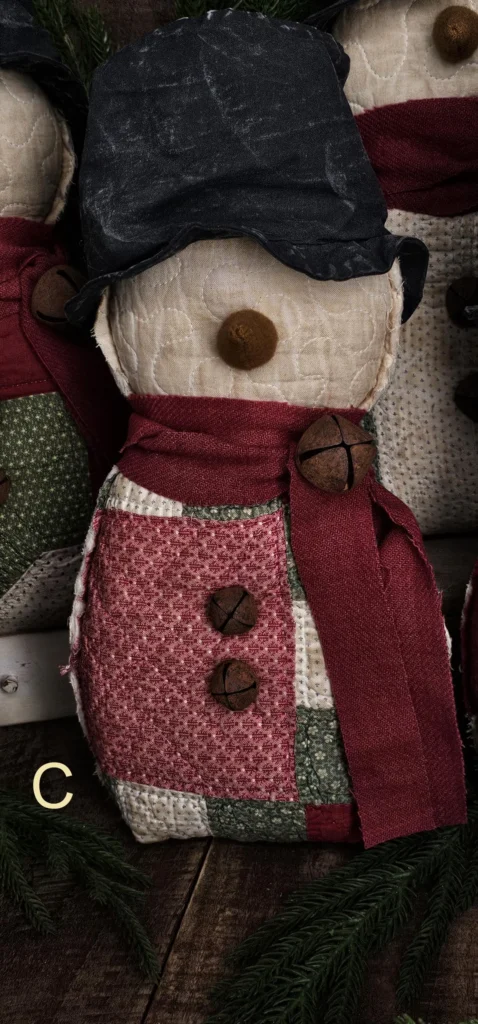 Primitive quilted snowman, Variant C, featuring lighter cream and red quilt patches and rustic textures; letter C shown on photo.
