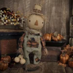 Primitive fall scarecrow doll with hand‑stitched face, gourds, and removable wooden crow.