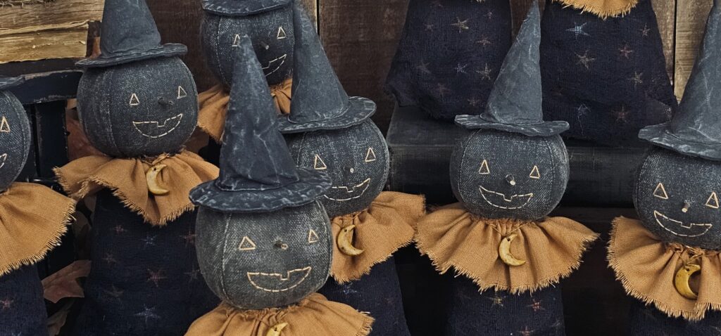 Close‑up of primitive moon witch face with stitched features and painted black fabric head.