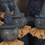 Close‑up of primitive moon witch face with stitched features and painted black fabric head.