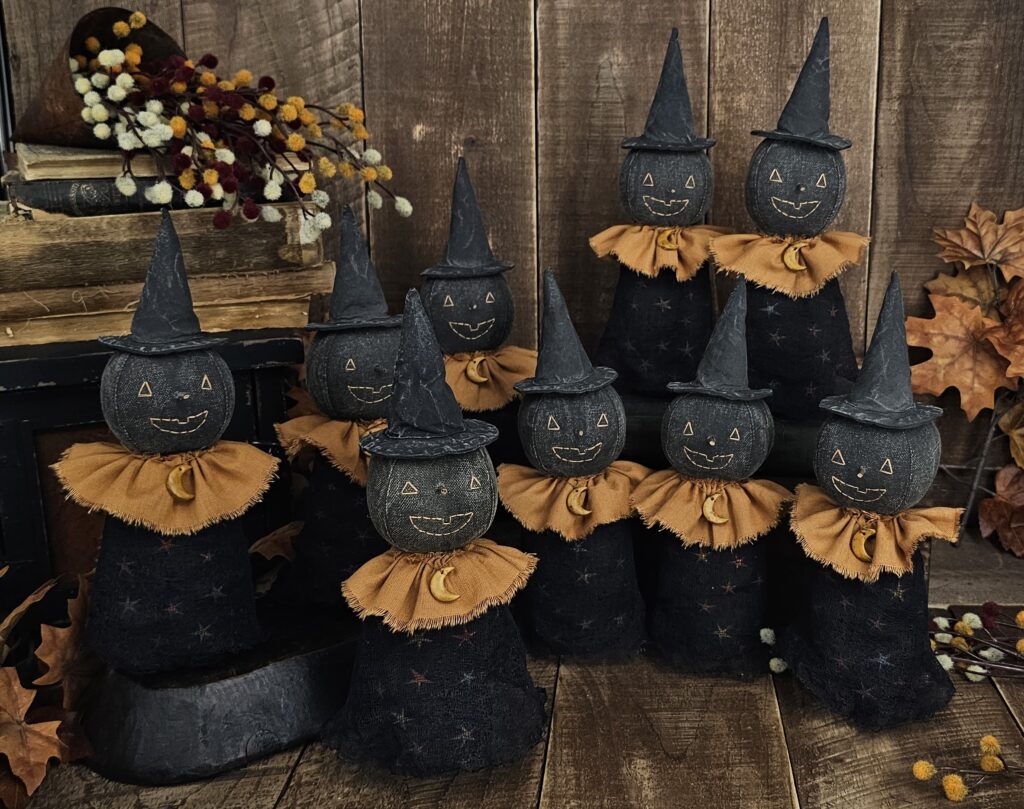 Primitive handmade moon witch with terracotta collar, clay moon necklace, star‑print body, and black witch hat for Halloween décor.